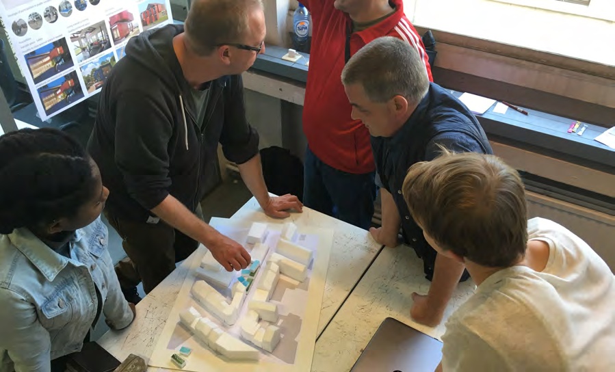 Students and housing partners discussing a physical model